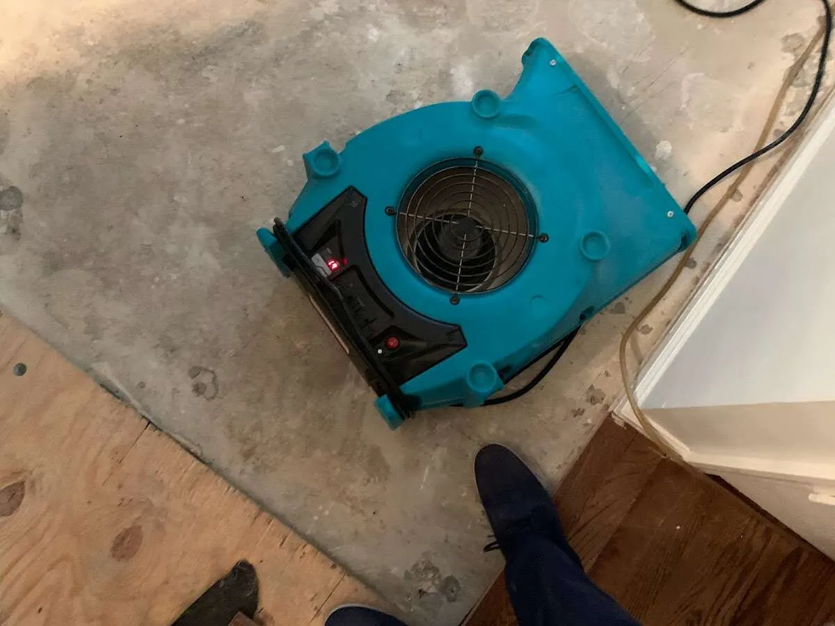 Air mover drying subfloor during Commercial Water Damage Restoration in Uniontown